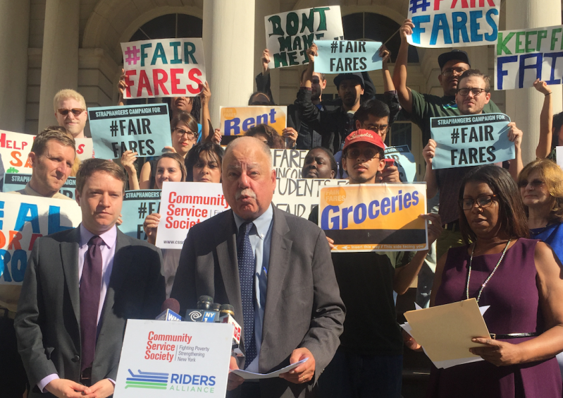 Community Service Society President David Jones (podium) speaking in October alongside Riders Alliance Executive Direction John Raskin (left) and Public Advocate Letitia James. Photo: David Meyer