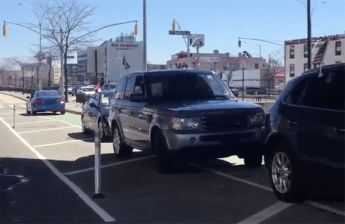 Car dealers aren't letting one of the city's flagship bike improvements get in the way of storing their inventory on public streets. Photo: Jessame Hannus