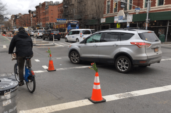 Two well-placed cones compel drivers to take safer turns across the First Avenue bike lane at 9th Street. Photo: Transformation Department