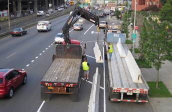 DOT crews installing a new barrier-protected bike lane on Bruckner Boulevard between Bryant Avenue and Faile Street. Photo: Twitter/NYC DOT