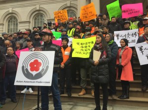 Delivery worker Liqiang Liu speaking on the steps of City Hall. Photo: David Meyer