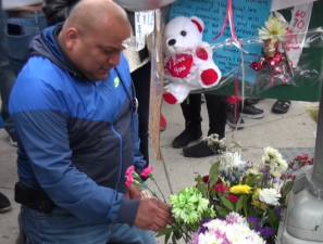 Raul Ampuero lays flowers at the memorial for his son Giovanni. Photo: Clarence Eckerson