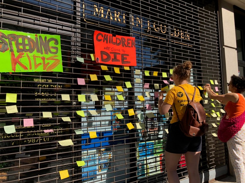 Marty Golden never showed up, so demonstrators stuck notes from constituents in support of speed cameras to his storefront grate to get his attention. Photo: Ben Fried