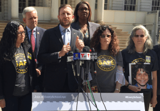 White, at podium, with advocates and elected officials in May of 2016. Photo: David Meyer