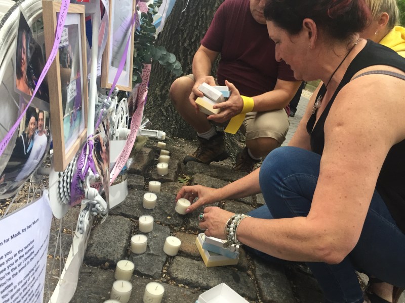 Madison Lyden's friend Carolyn Bischof lights candles at the memorial bike's September installation. Photo: David Meyer