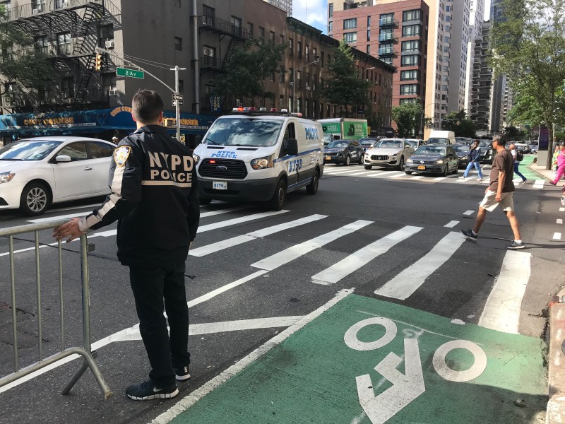 An officer from the 19th Precinct checks on the so-called protected bike lane Friday afternoon. Photo: Julianne Cuba.