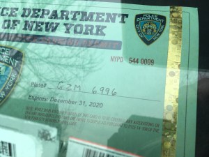 The SUV on which this police placard was displayed this week had seven school-zone speed-camera and five other violations dating back to 2015. Photo: Eve Kessler