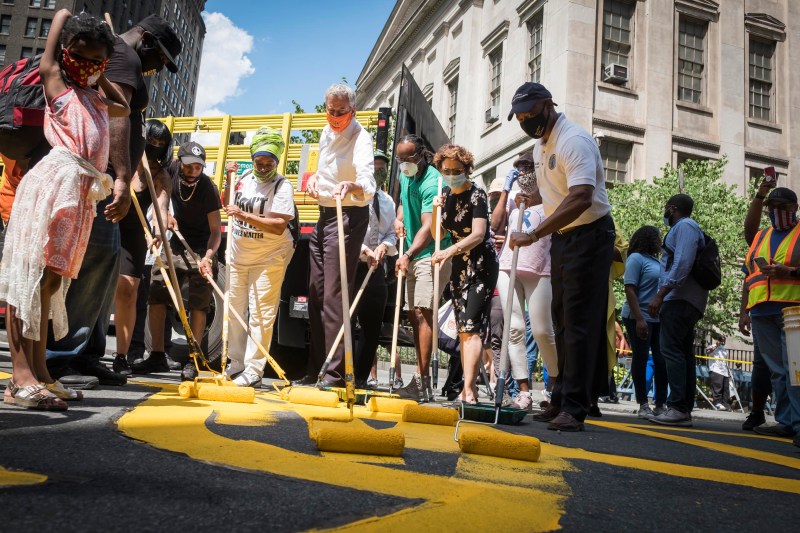 Mayor de Blasio helps paint one of the Black Lives Matter murals. Courtesy of Mayor's Office