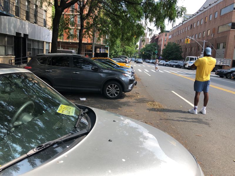 On Wednesday, police officers' personal vehicles still filled the M10 bus stop, one day after Mayor de Blasio and the NYPD said the situation would change. Photo: Adam Light