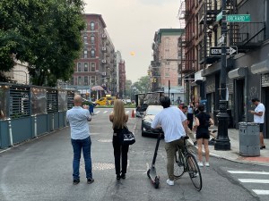 People on the street take photos of a blood red sun created by smoke from Oregon's wildfires.