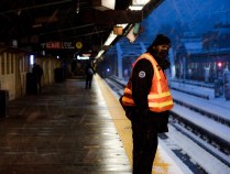 A worker surveys the snow on an elevated subway platform. Photo: MTA