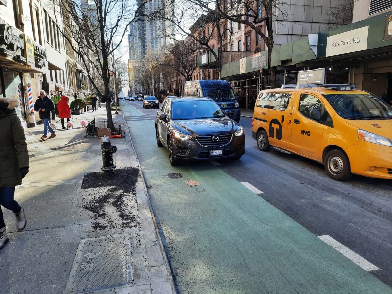A motorist invades the bike lane at the precise spot where a Baldor truck driver mowed down two people last month. The city has fixed the hydrant the driver squashed, but not the defective lane. Photo: Liam Jeffries