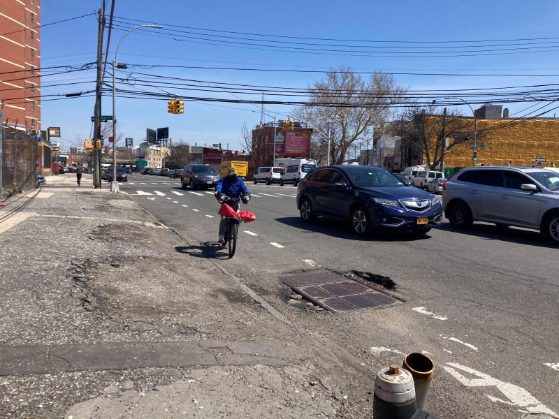 A delivery cyclist riding on the crumbling roads in Blissville, Queens. Photo: Julianne Cuba