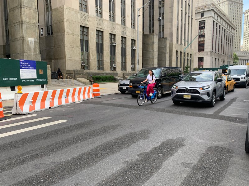 As you (and this endangered cyclist) can see, the city has started scrubbing some lines and adding others to carve out a protected bike lane on Centre Street. Photos: Gersh Kuntzman
